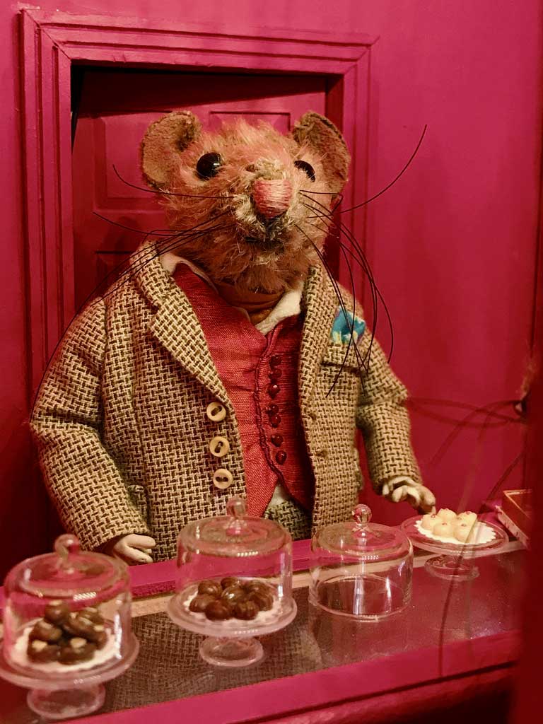 Claude the mohair mouse behind the counter of his dollhouse chocolate shop